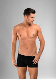 Photo of Handsome man in black underwear on light grey background