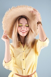 Beautiful young woman in hat on color background. Summer fashion