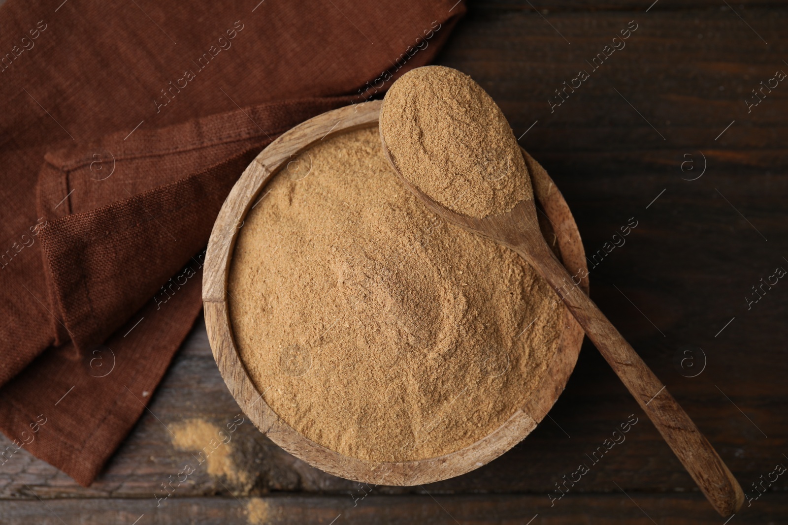 Photo of Dietary fiber. Psyllium husk powder in bowl and spoon on wooden table, top view