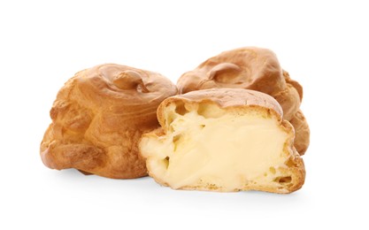 Photo of Cut and whole delicious profiteroles with cream filling on white background