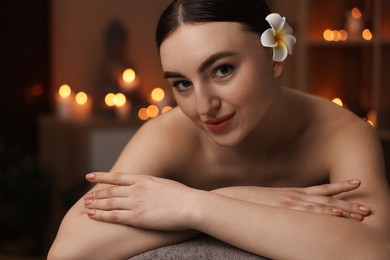 Photo of Spa therapy. Beautiful young woman lying on massage table in salon