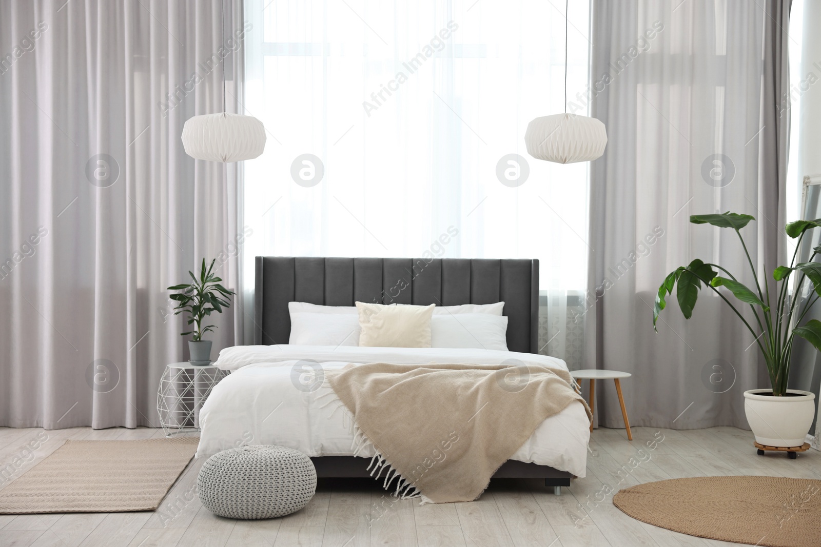 Photo of Soft beige plaid on bed in stylish bedroom. Interior design