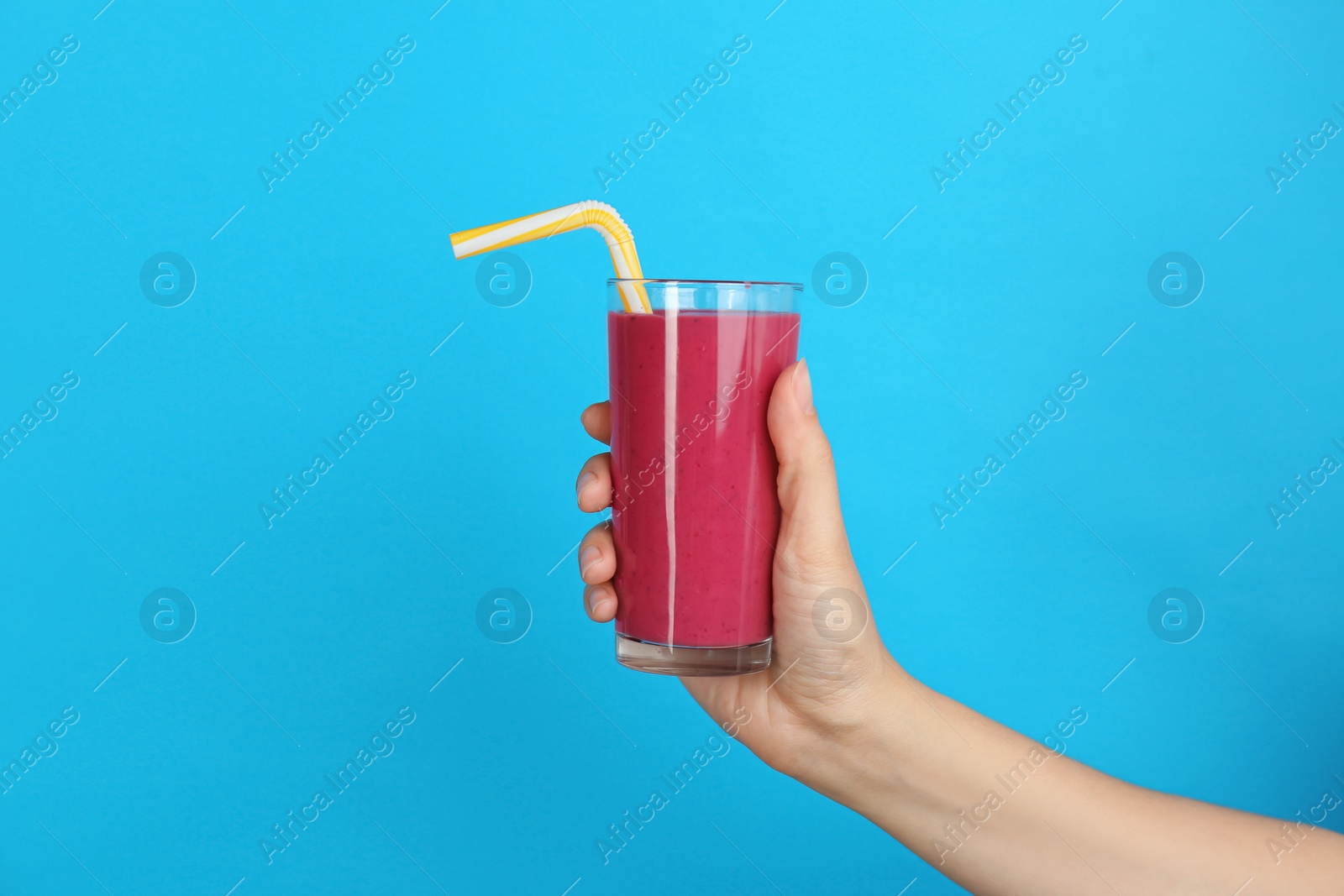 Photo of Woman holding glass with delicious smoothie on color background