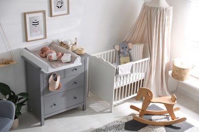 Cute little baby on changing table in room