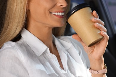Photo of To-go drink. Woman drinking coffee in car, closeup