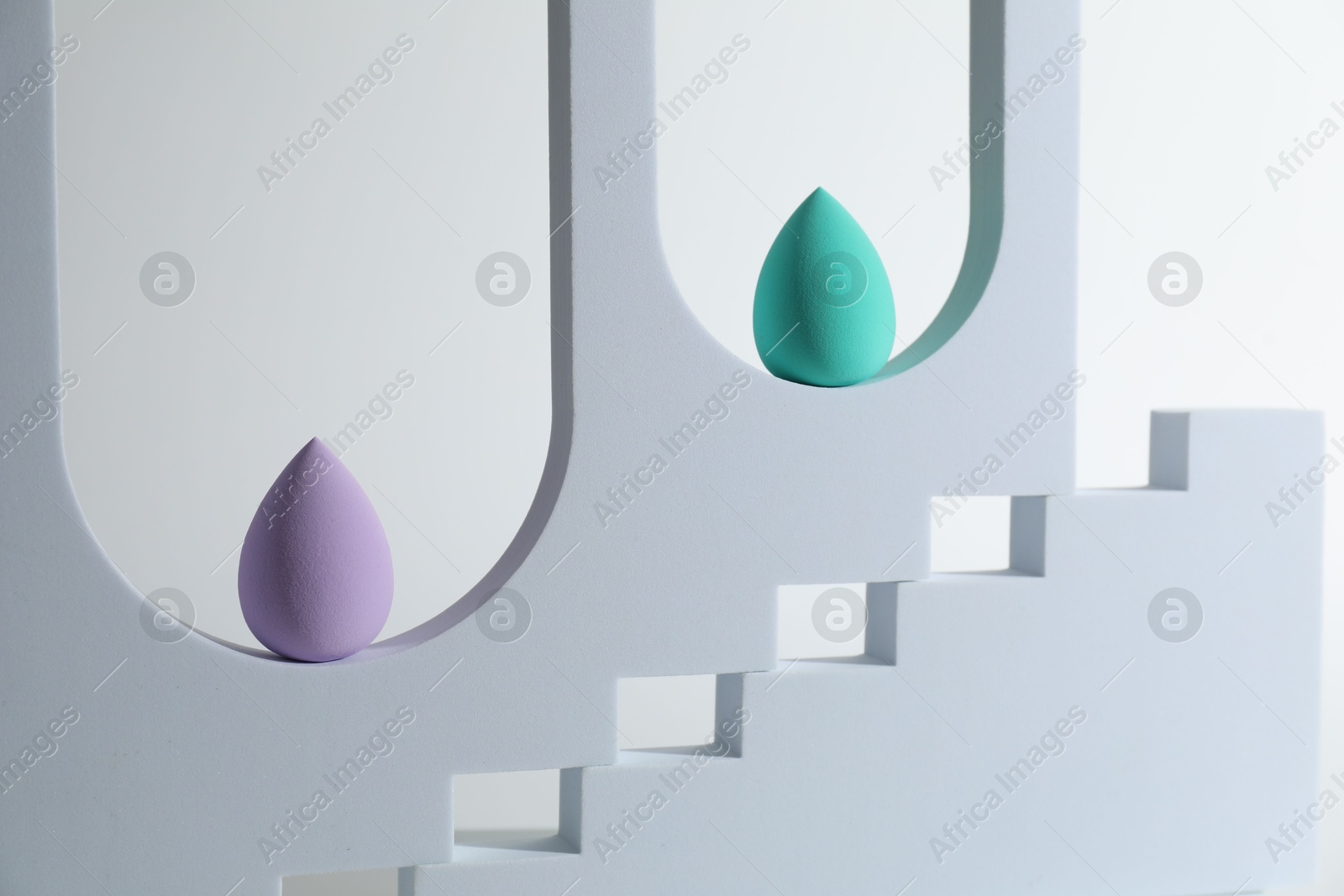 Photo of Stylish presentation of makeup sponges on white background