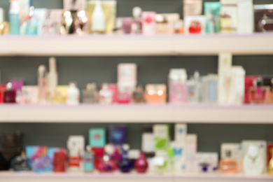 Blurred view of shelves with perfume bottles in shop