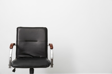 Photo of Comfortable office chair on light background. Space for text