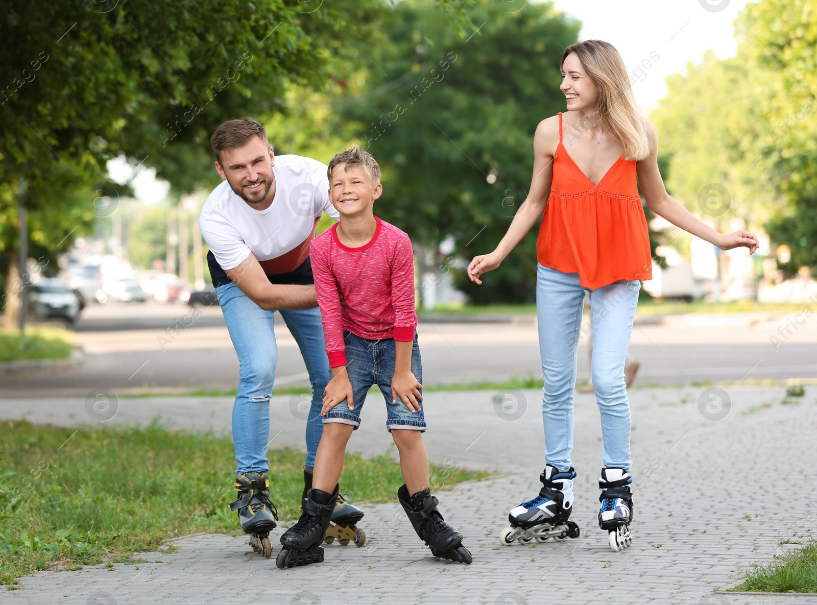 Photo of Young happy family roller skating on city street