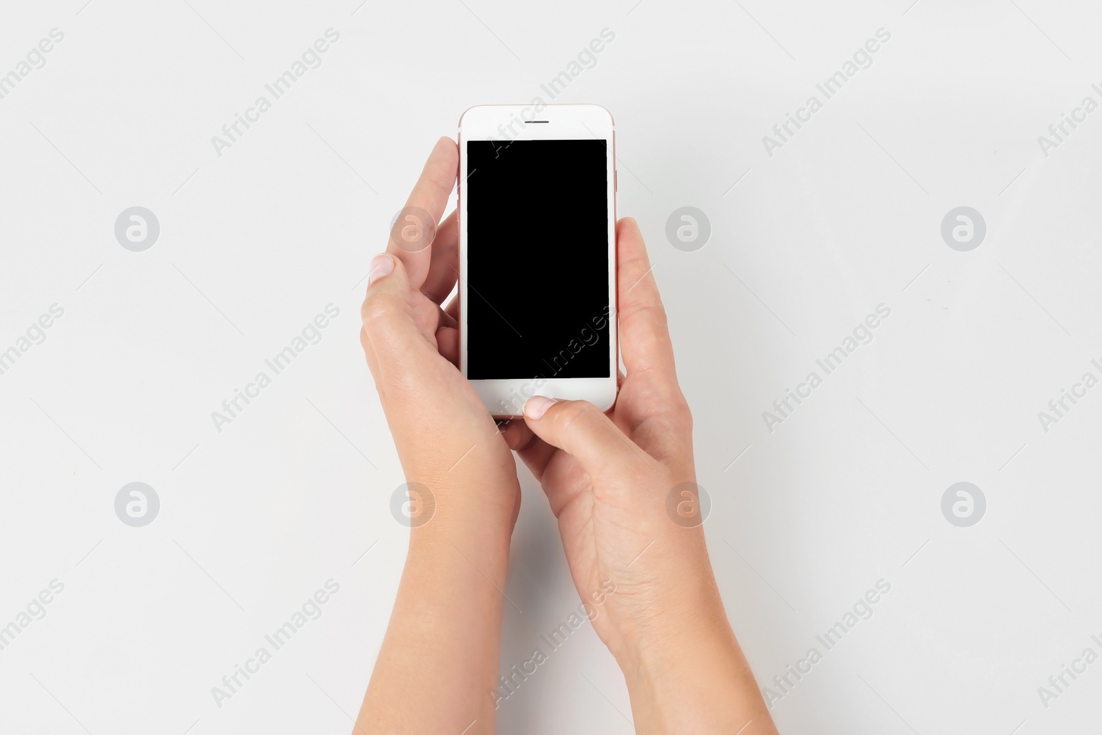 Photo of Young woman holding mobile phone with blank screen in hands on white background