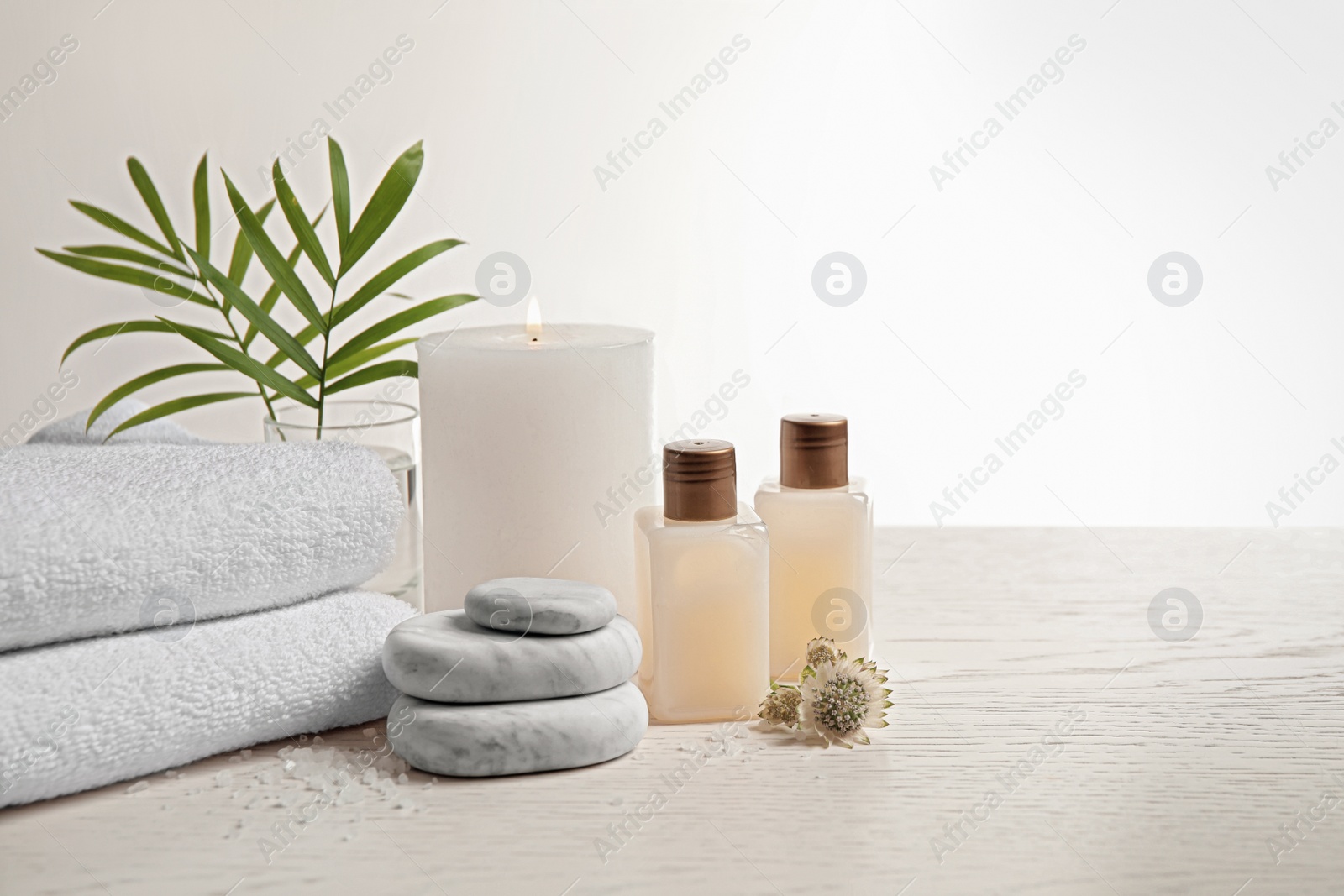 Photo of Composition with spa stones on white wooden table. Space for text