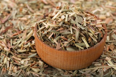 Photo of Wooden bowl and aromatic dried lemongrass, closeup