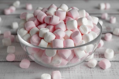 Photo of Glass bowl with delicious marshmallows on wooden table, closeup