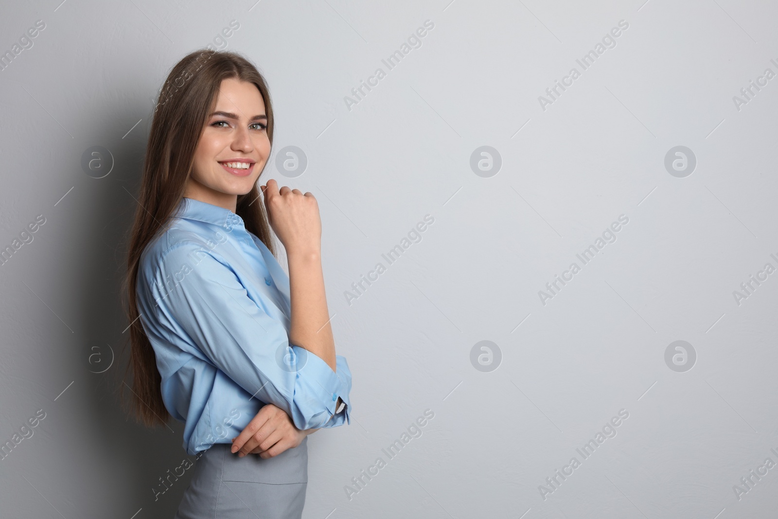 Photo of Beautiful real estate agent on grey background