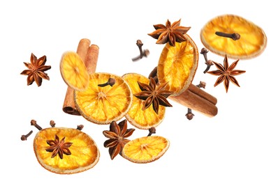 Image of Slices of dried orange, aromatic anise stars, cinnamon and cloves falling on white background