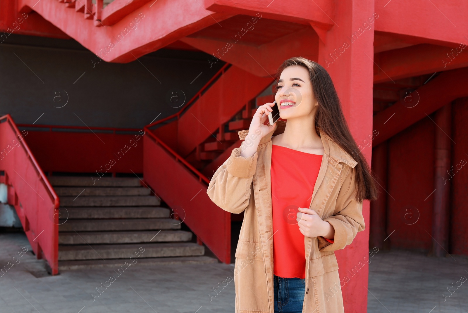 Photo of Young woman talking on mobile phone outdoors