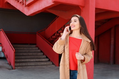 Photo of Young woman talking on mobile phone outdoors