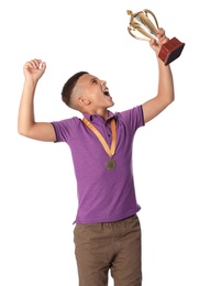 Photo of Happy boy with golden winning cup and medal on white background