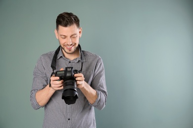 Photo of Male photographer with camera on grey background