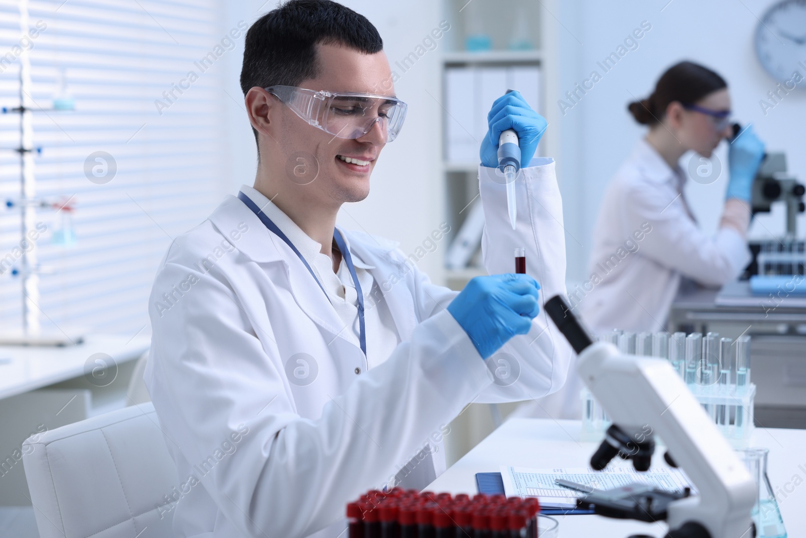 Photo of Scientist dripping sample into test tube in laboratory