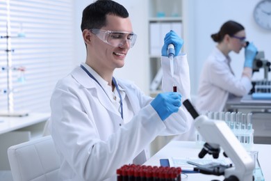 Scientist dripping sample into test tube in laboratory