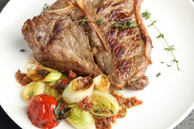 Photo of Delicious fried beef meat and vegetables on plate, closeup