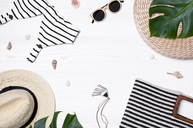 Flat lay composition with beach bag and accessories on white wooden background