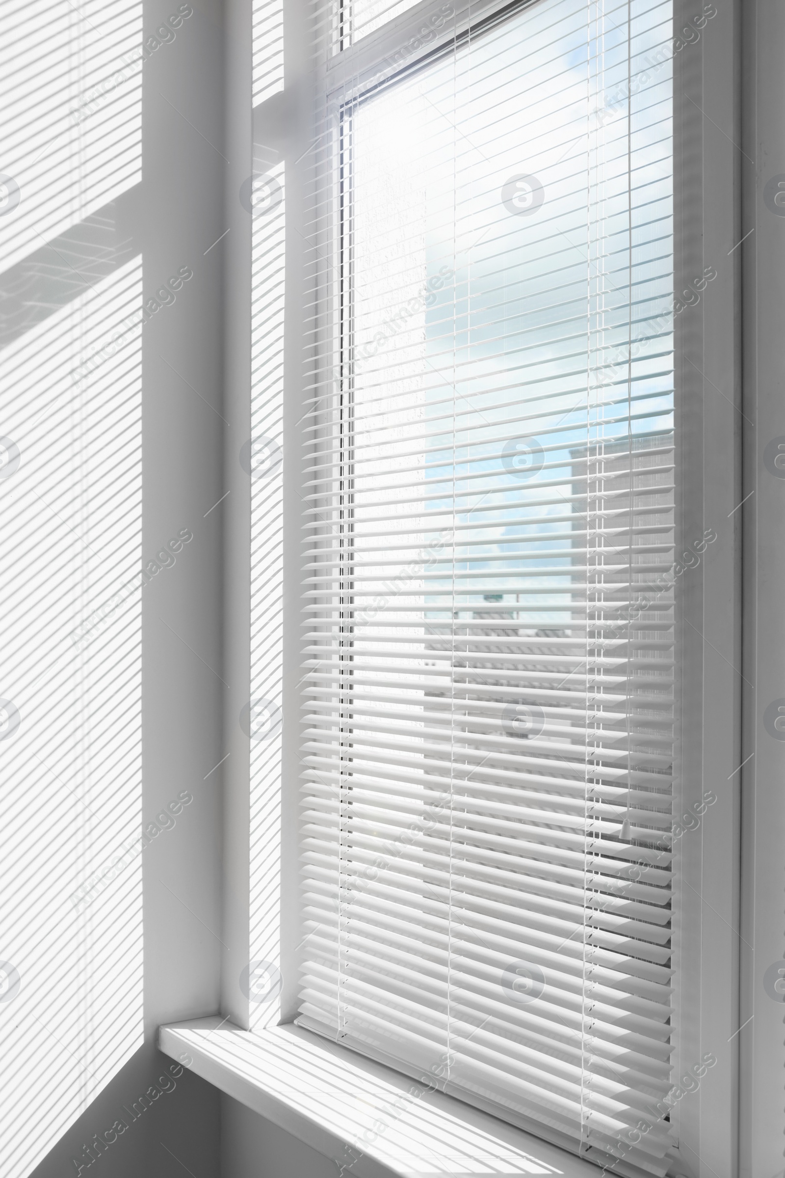 Photo of Stylish window with horizontal blinds in room