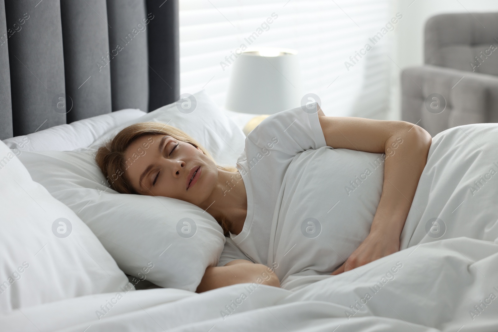 Photo of Woman snoring while sleeping in bed at home