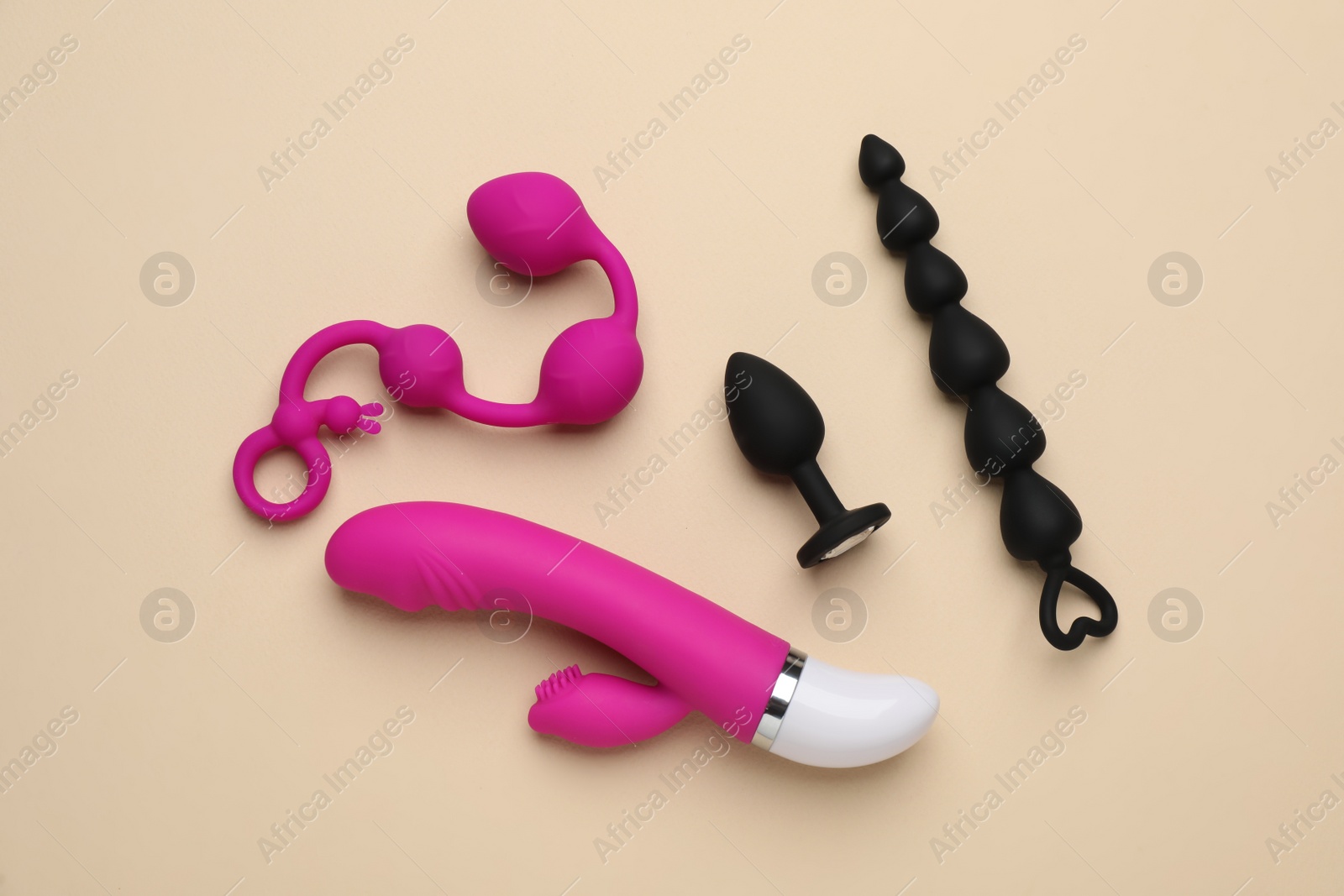 Photo of Sex toys on beige background, flat lay