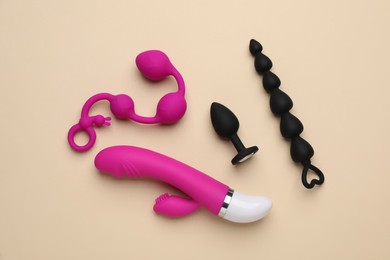 Sex toys on beige background, flat lay
