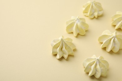 Delicious meringue cookies on beige background, closeup. Space for text