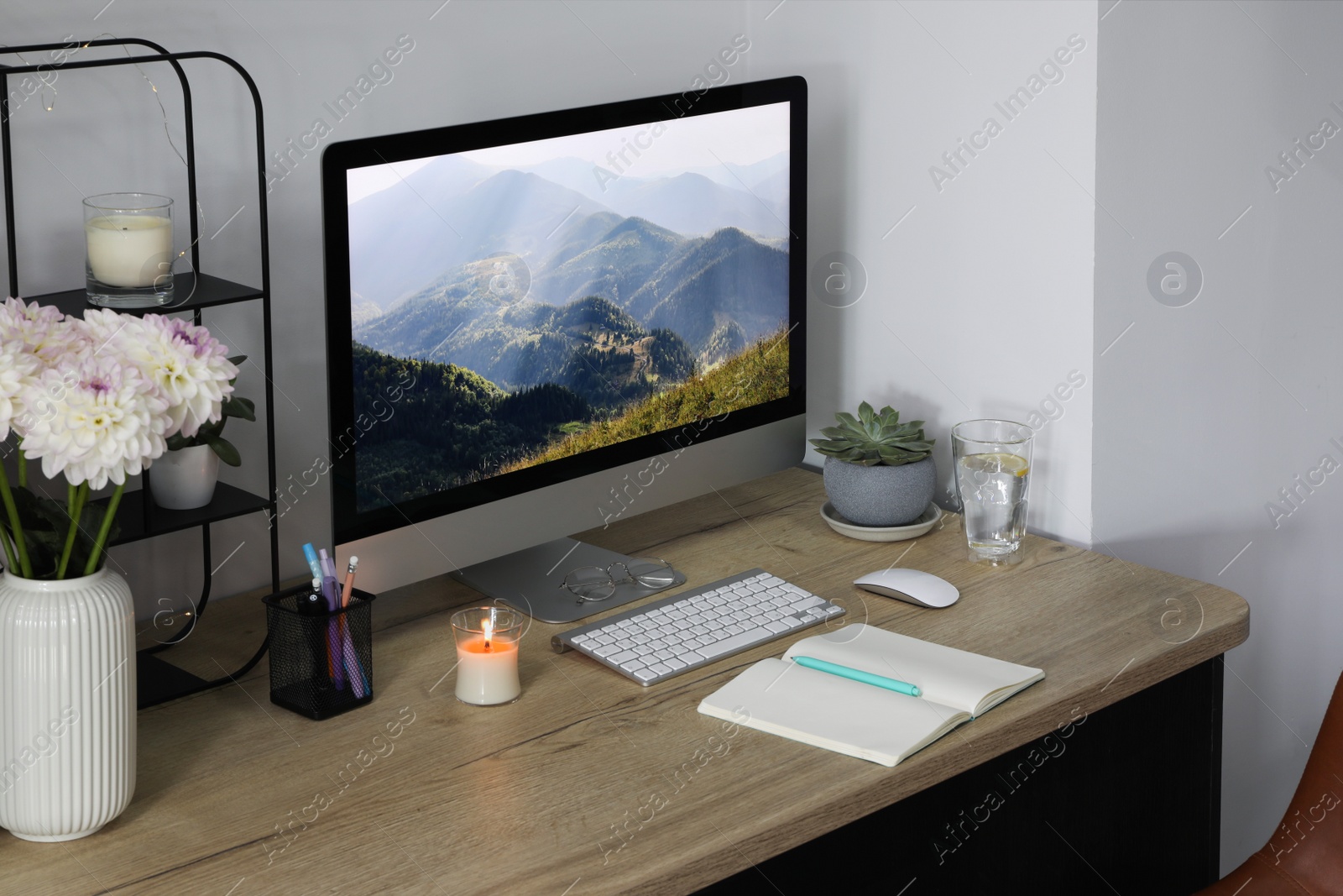 Photo of Comfortable workplace with modern computer, decor and office supplies on wooden table indoors