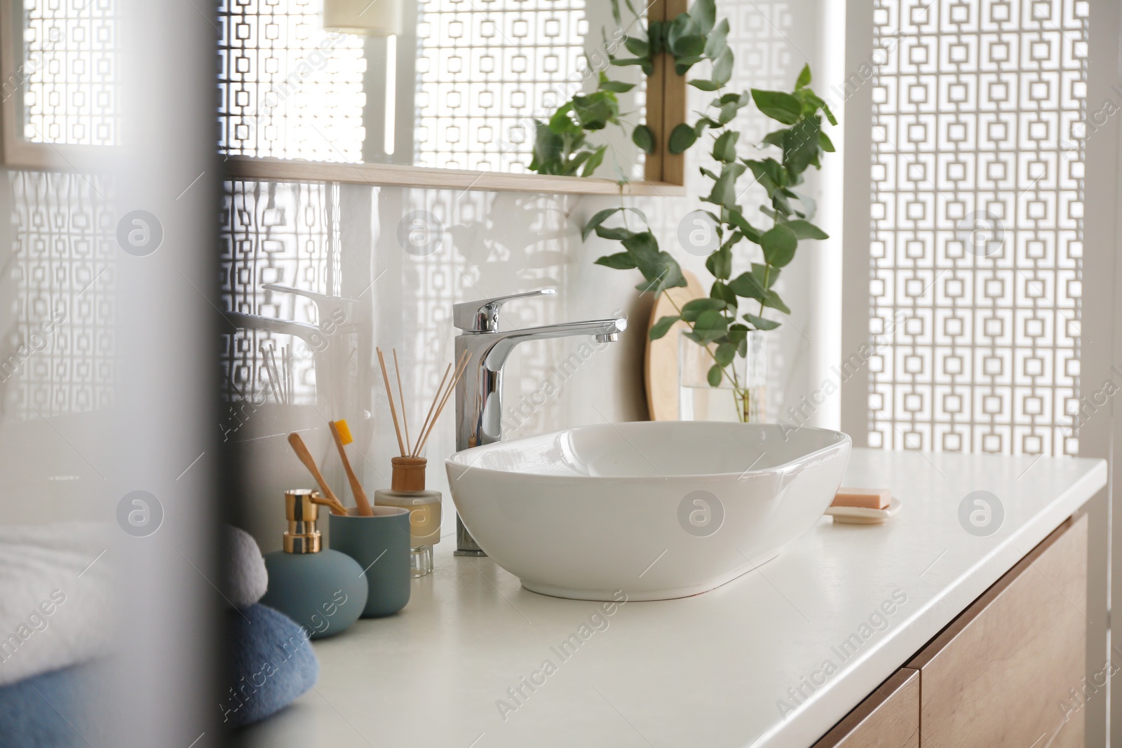 Photo of Stylish vessel sink under mirror in bathroom. Interior element