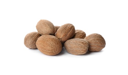 Photo of Heap of nutmeg seeds on white background