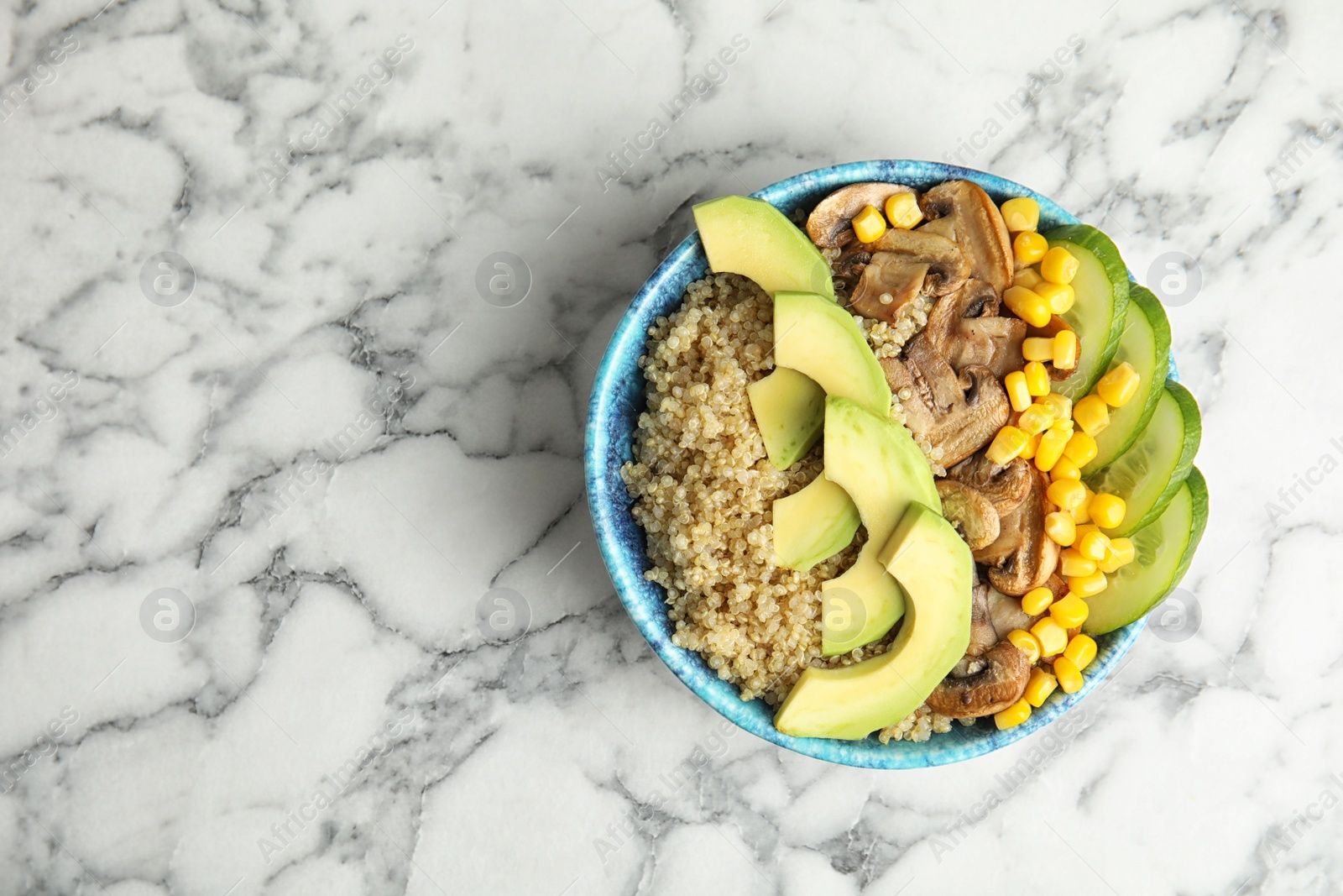 Photo of Bowl with quinoa and garnish on table, top view. Space for text