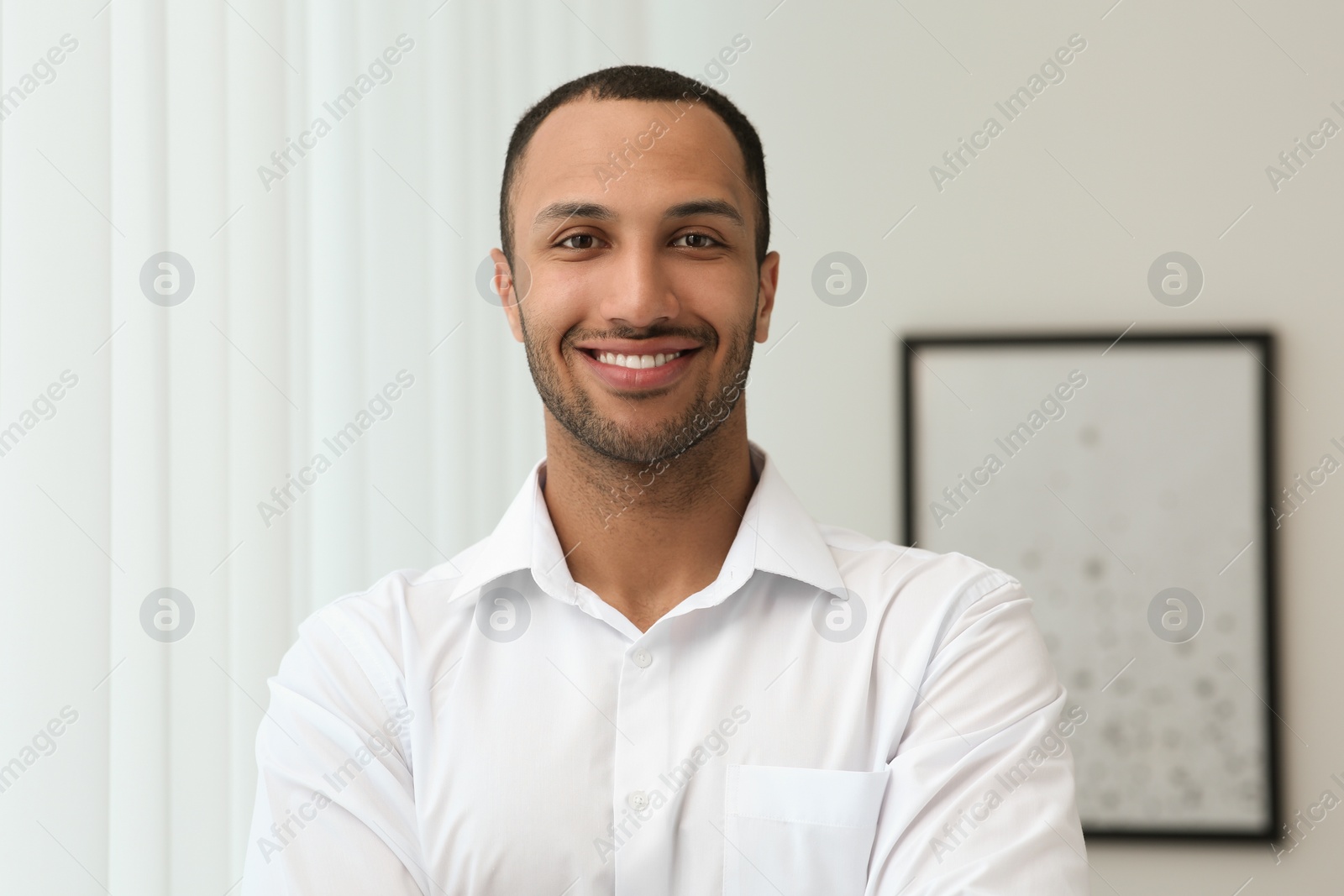 Photo of Portrait of handsome young man in white shirt indoors