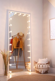 Image of Full length dressing mirror with lamps in stylish room interior