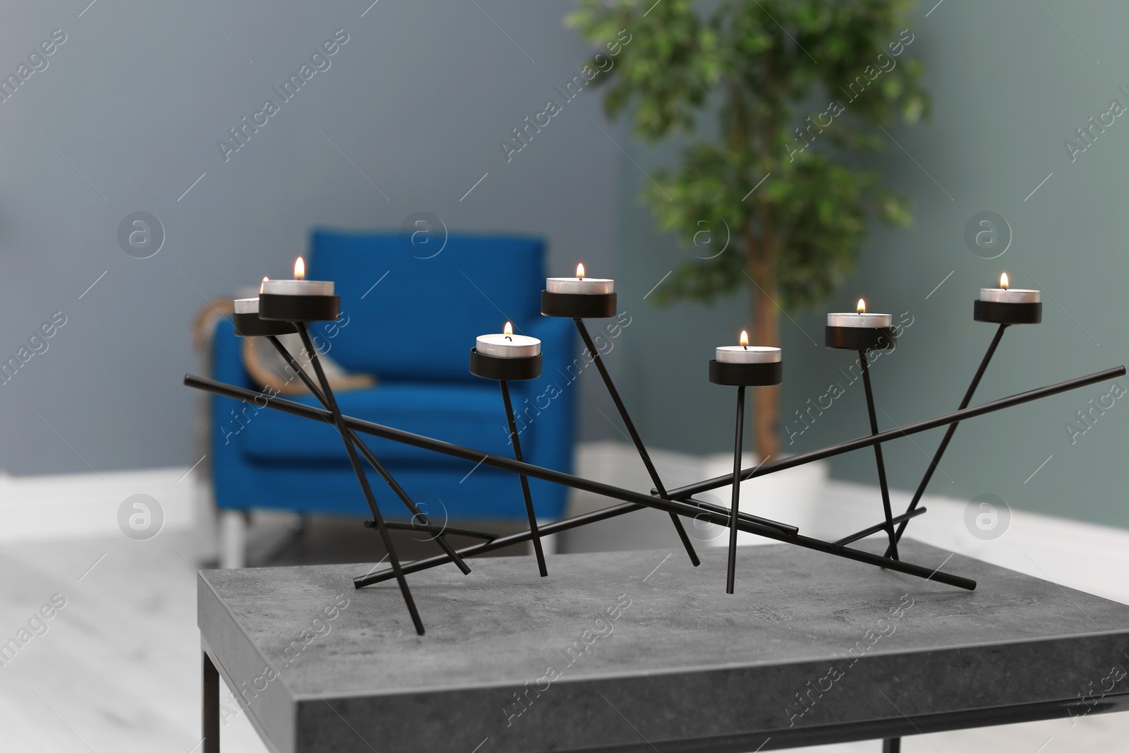 Photo of Burning candles on table indoors. Interior decor element