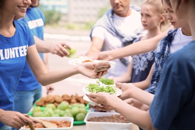 Photo of Volunteers serving food for poor people outdoors