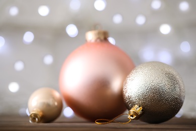 Photo of Beautiful Christmas balls on table against blurred festive lights