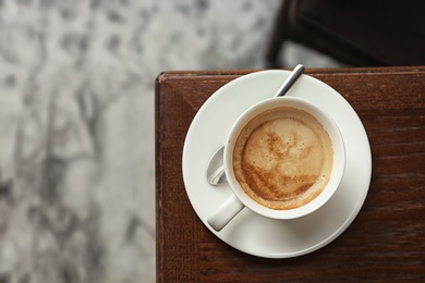 Photo of Cup of delicious aromatic coffee on table, top view