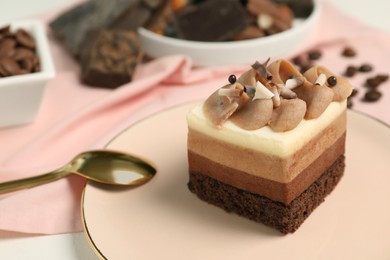 Photo of Piece of triple chocolate mousse cake and spoon on table, closeup with space for text