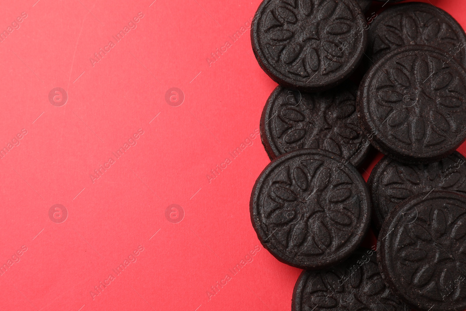 Photo of Tasty sweet sandwich cookies on red background, flat lay. Space for text