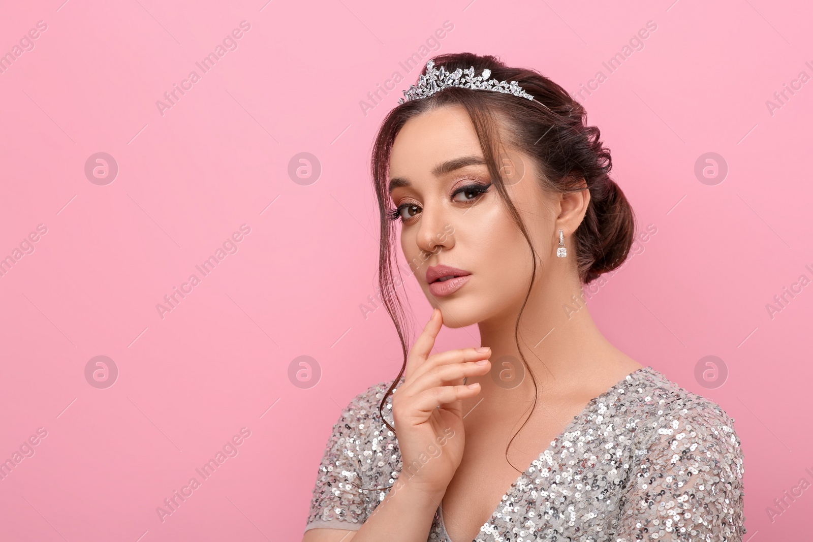 Photo of Beautiful young woman wearing luxurious tiara on pink background, space for text