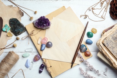 Photo of Flat lay composition with different gemstones on white wooden background