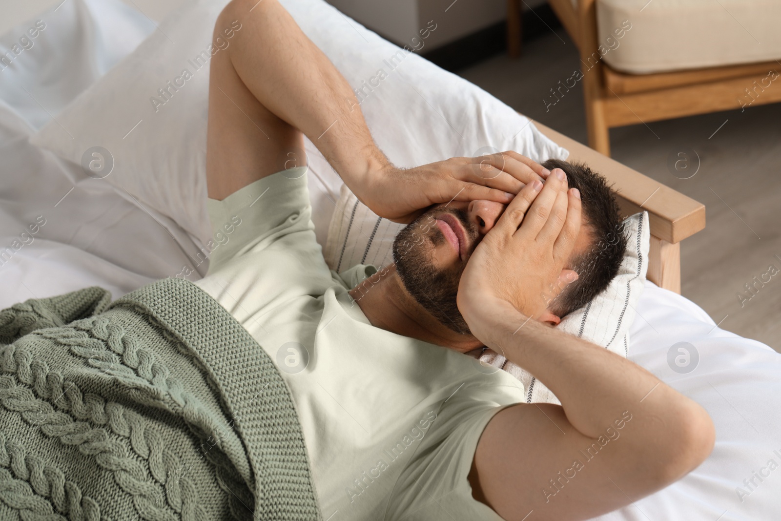 Photo of Sleepless man lying in bed at home