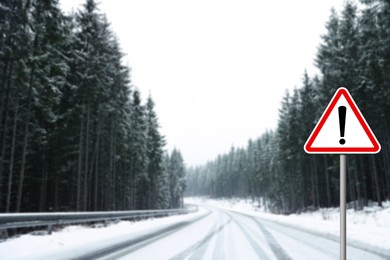 Traffic sign DANGER near snowy road going through coniferous forest in winter