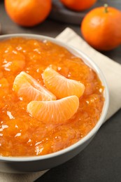 Tasty tangerine jam in bowl on table, closeup