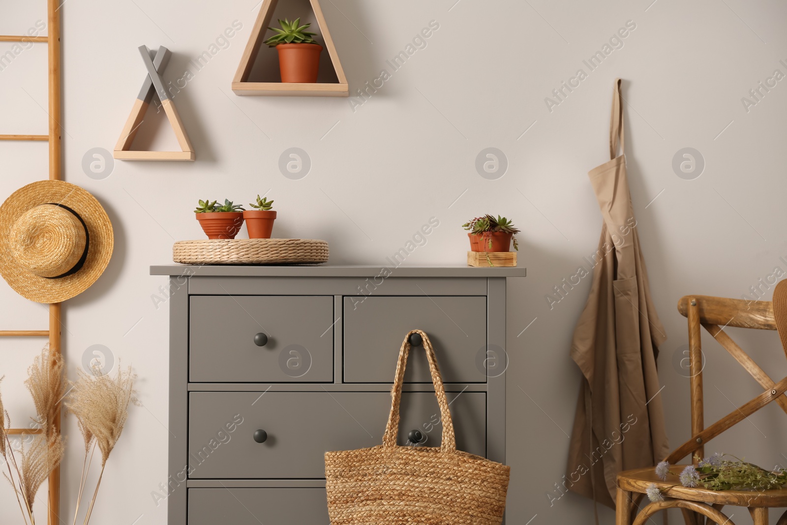 Photo of Grey chest of drawers in stylish room interior